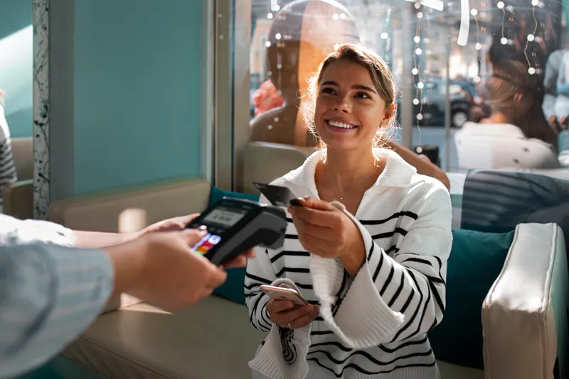 woman paying with smartphone cafe